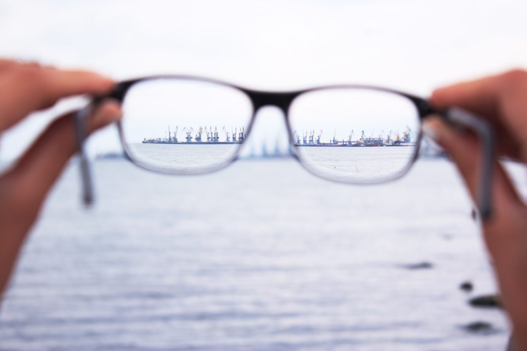 Hands holding a pair of glasses with only the image in the frames in focus