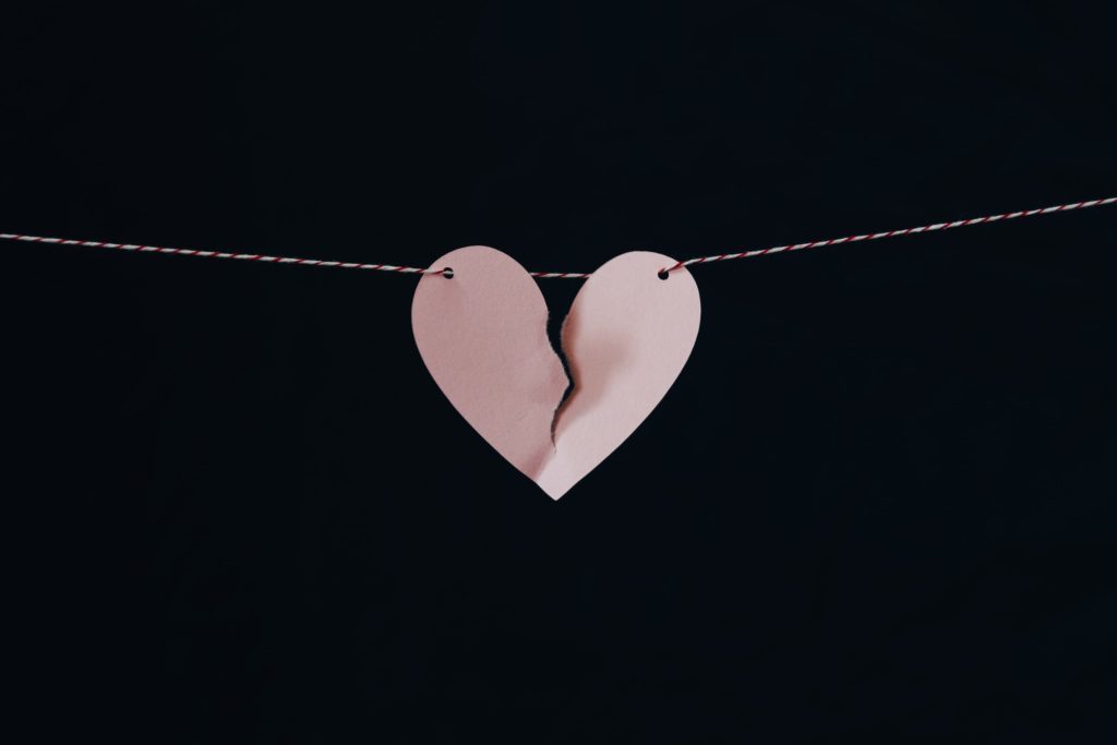 Broken paper heart hanging from a string